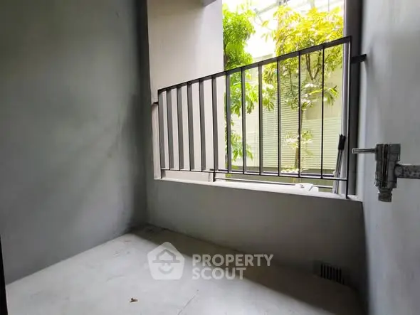 Small balcony with metal railing and view of greenery, ideal for urban living.