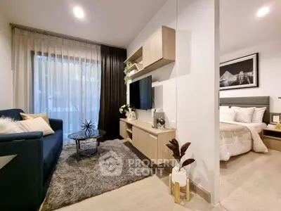 Modern open-concept living room with cozy bedroom, stylish decor, and natural light.