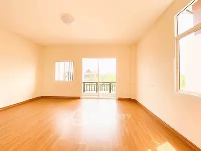Spacious empty room with wooden flooring and balcony view, perfect for customization.