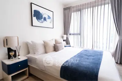 Modern bedroom with stylish decor and large window for natural light.