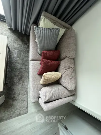 Cozy living room with modern sofa and stylish cushions, perfect for relaxation.