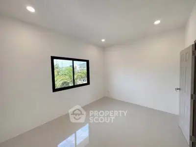 Spacious unfurnished room with large window and modern lighting, perfect for customization.