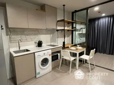 Modern kitchen with washing machine and dining area in open layout apartment