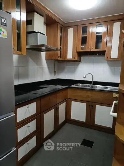 Charming kitchen with wooden cabinets and modern appliances in cozy apartment