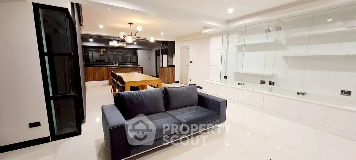 Spacious modern living room with open kitchen and elegant lighting