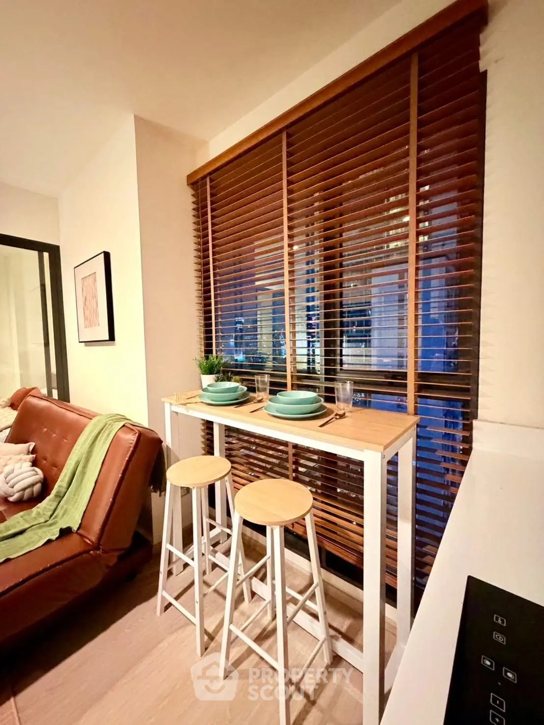 Cozy living room with stylish bar seating and large window blinds