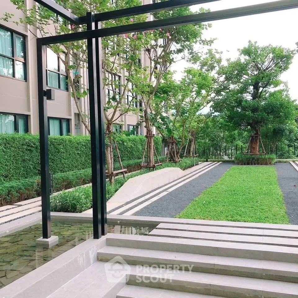 Elegant garden view with lush greenery and modern architecture in a residential complex.