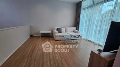 Spacious living room with modern decor and large windows offering natural light.