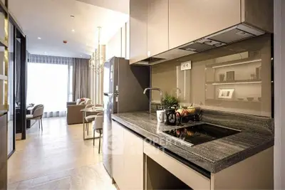 Modern kitchen with sleek design and open layout leading to a bright living area.