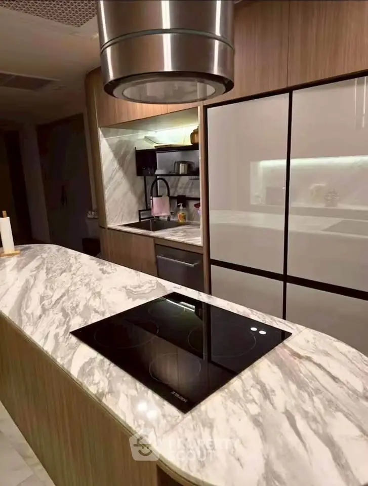 Modern kitchen with marble countertops and sleek appliances in a luxurious home.