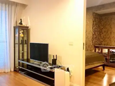 Stylish modern living room with TV unit and glimpse of elegant bedroom