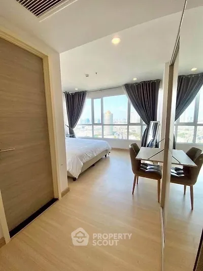 Spacious bedroom with large windows offering stunning city views, modern furnishings, and elegant decor.