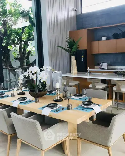 Luxurious dining area with elegant table setting and modern kitchen in open layout design.