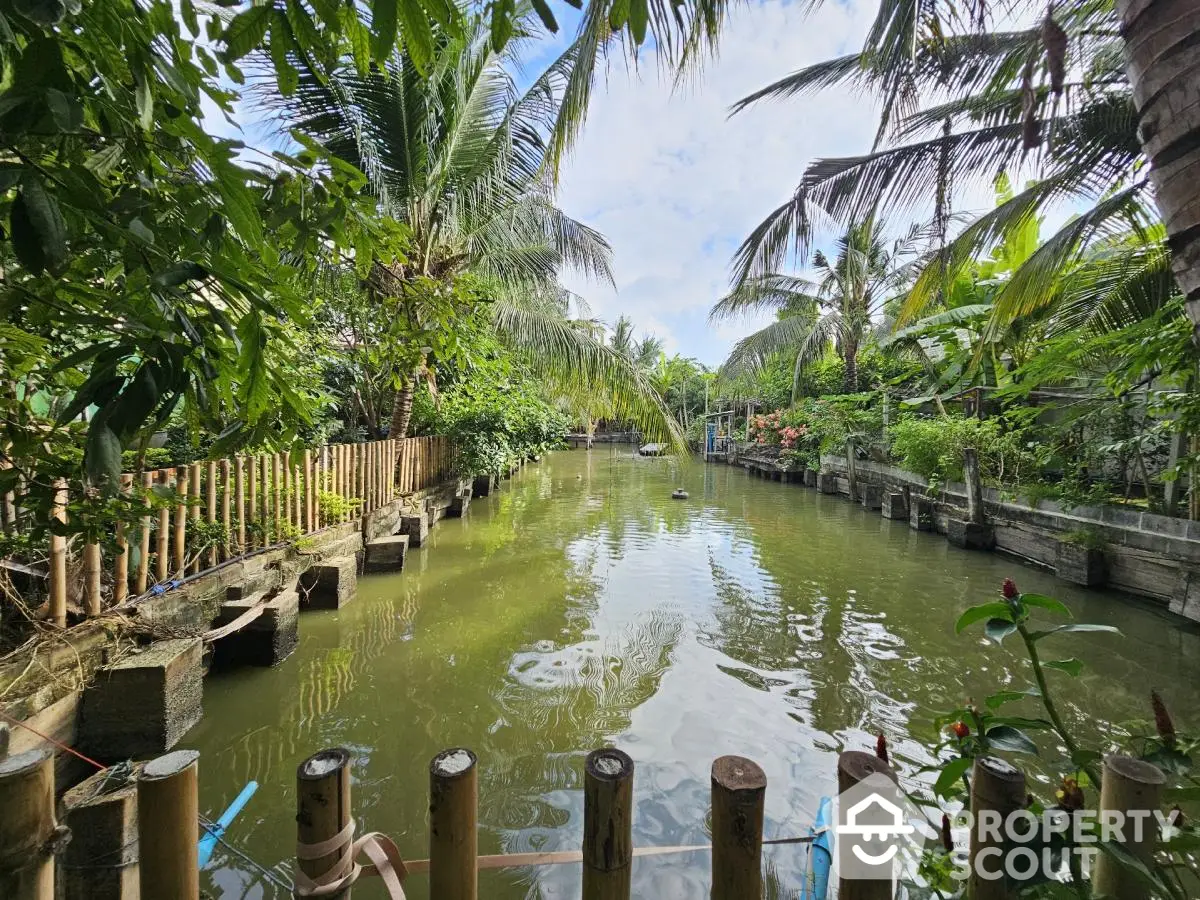 Tropical garden view with lush greenery and serene waterway, perfect for nature lovers seeking tranquility.