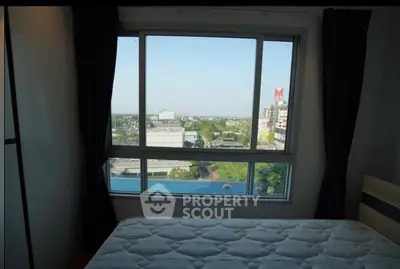 Bedroom with large window offering stunning city view and natural light