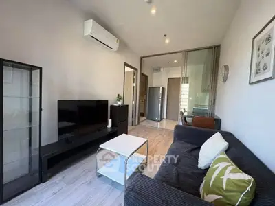 Modern living room with sleek furniture and open layout, featuring a cozy sofa and stylish decor.