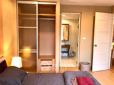 Cozy bedroom with open closet and ensuite bathroom in modern apartment