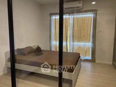 Modern bedroom with glass partition and natural light, featuring minimalist design and cozy ambiance.