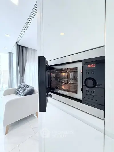 Modern kitchen with built-in microwave and sleek white cabinetry