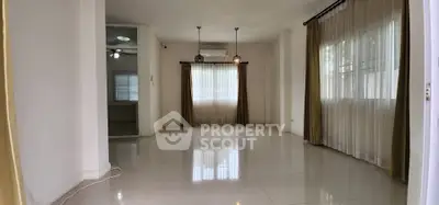 Spacious empty living room with large windows and elegant curtains