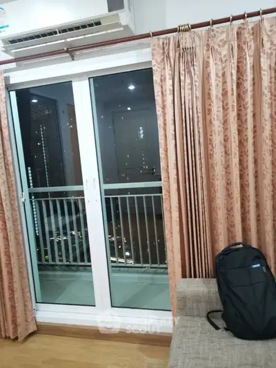 Cozy living room with balcony access and elegant curtains