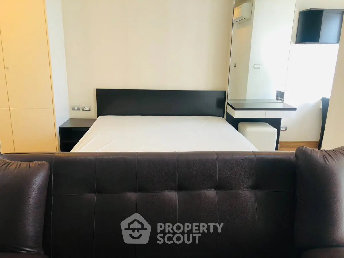 Modern bedroom with sleek furniture and neutral tones, featuring a comfortable bed and stylish decor.