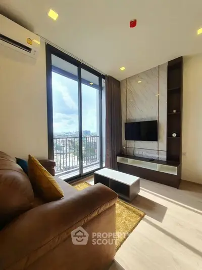 Modern living room with large windows and city view, featuring a cozy sofa and wall-mounted TV.