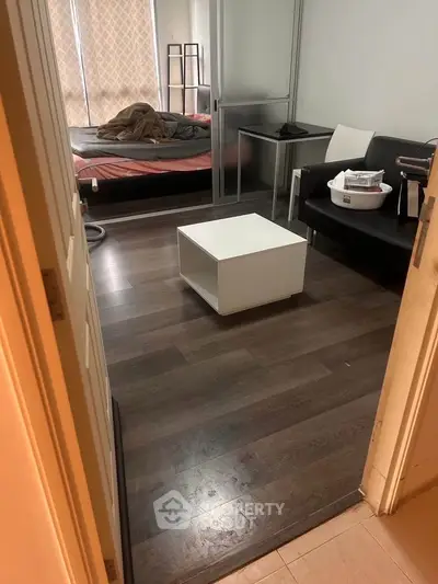 Cozy bedroom with modern furnishings and wooden flooring, perfect for urban living.