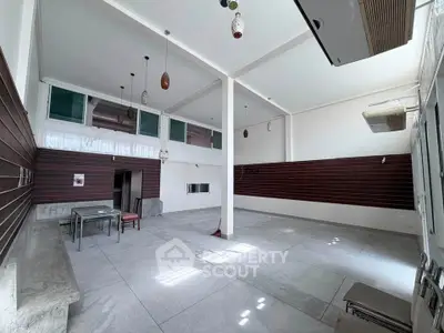 Spacious open-plan room with high ceilings and modern lighting, ideal for versatile use.