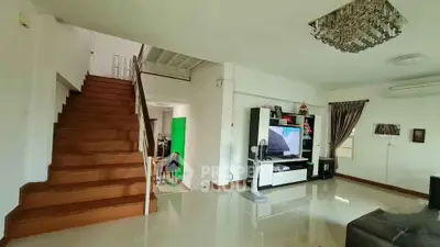 Spacious living room with modern decor and elegant staircase in a stylish home.