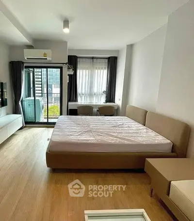 Modern bedroom with balcony access and natural light in urban apartment