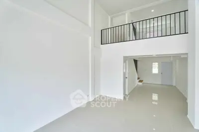 Spacious modern interior with high ceilings and mezzanine level, perfect for contemporary living.