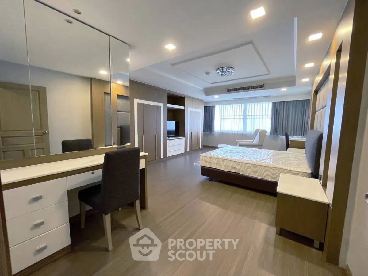 Spacious modern bedroom with elegant decor and ample natural light.