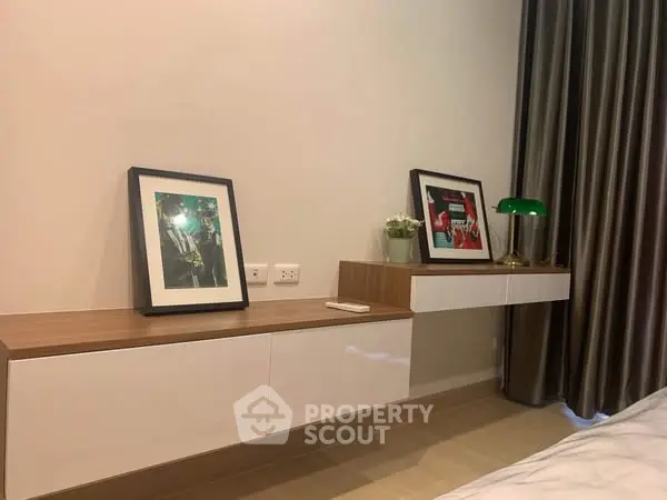Modern bedroom with floating shelves and framed art, elegant decor.