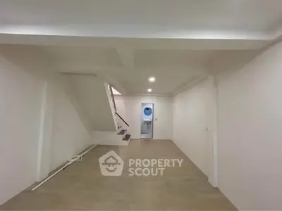 Spacious unfurnished room with staircase and modern lighting