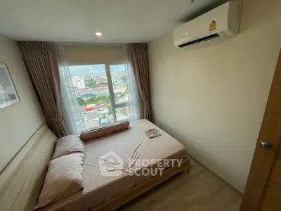 Cozy bedroom with large window offering city views, featuring a comfortable bed and air conditioning.