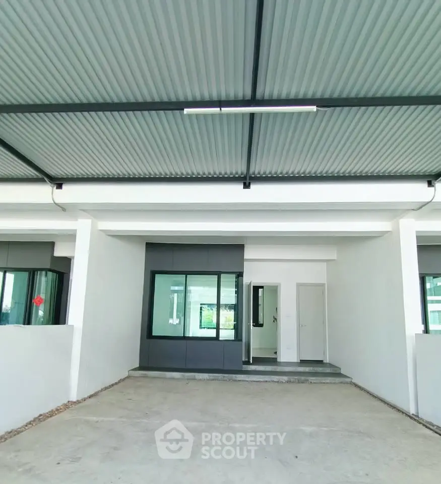 Modern minimalist house exterior with covered parking and sleek design.