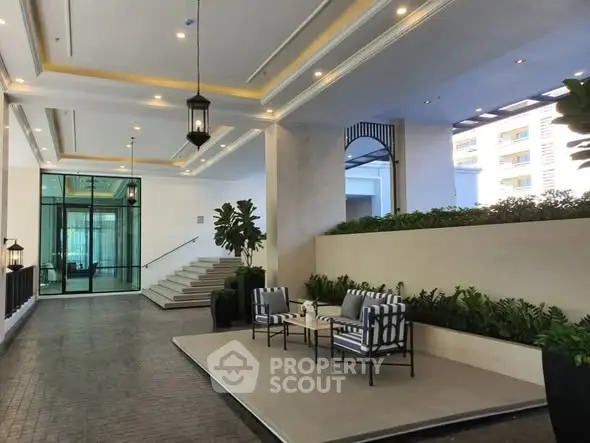 Elegant building entrance with stylish seating and lush greenery