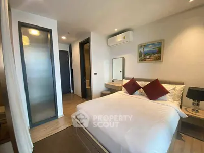 Modern bedroom with stylish decor and natural light, featuring a cozy bed and elegant furnishings.