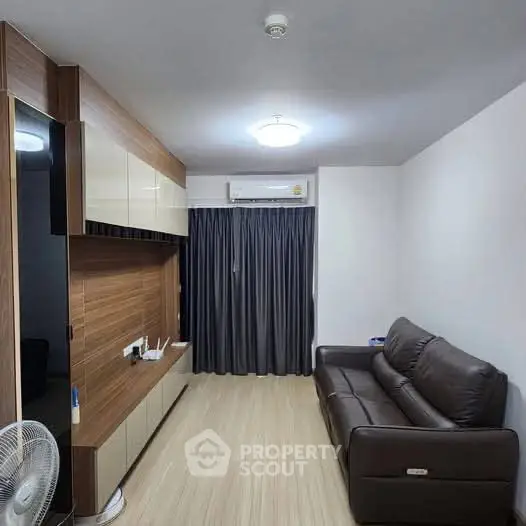 Modern living room with sleek furniture and air conditioning, featuring a cozy sofa and stylish wood paneling.