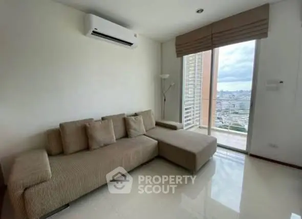 Modern living room with large sofa and city view balcony