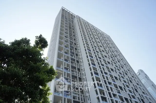 Modern high-rise building with sleek architecture and large windows in urban setting.