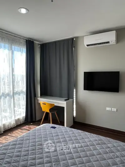 Modern bedroom with large window, desk, and wall-mounted TV in a stylish apartment.