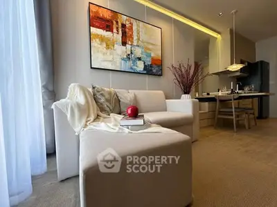 Modern living room with elegant decor and open dining area, featuring stylish furniture and contemporary artwork.