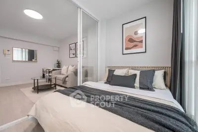 Modern bedroom with stylish decor and cozy living area in open layout apartment.