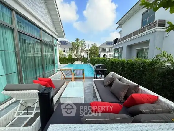 Luxurious outdoor patio with modern furniture and pool in a serene residential setting.