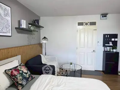 Modern bedroom with stylish decor, featuring a cozy bed, elegant lighting, and a chic seating area.