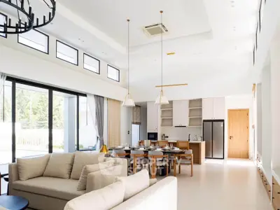 Spacious open-layout living room and kitchen with modern decor and natural light.