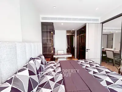 Modern bedroom with stylish geometric bedding and sleek furniture in a contemporary apartment.