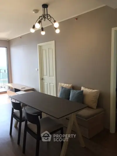 Modern dining area with stylish lighting and cozy seating in a contemporary apartment.